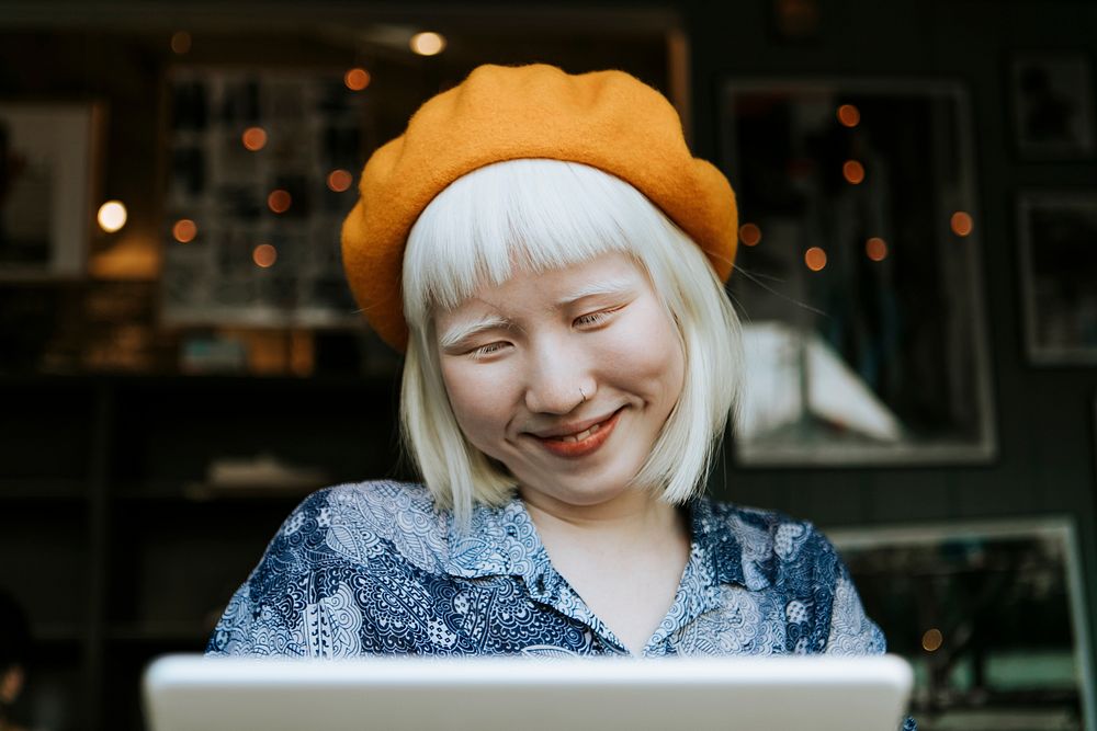 Cut albino girl talking to her friends through a digital tablet