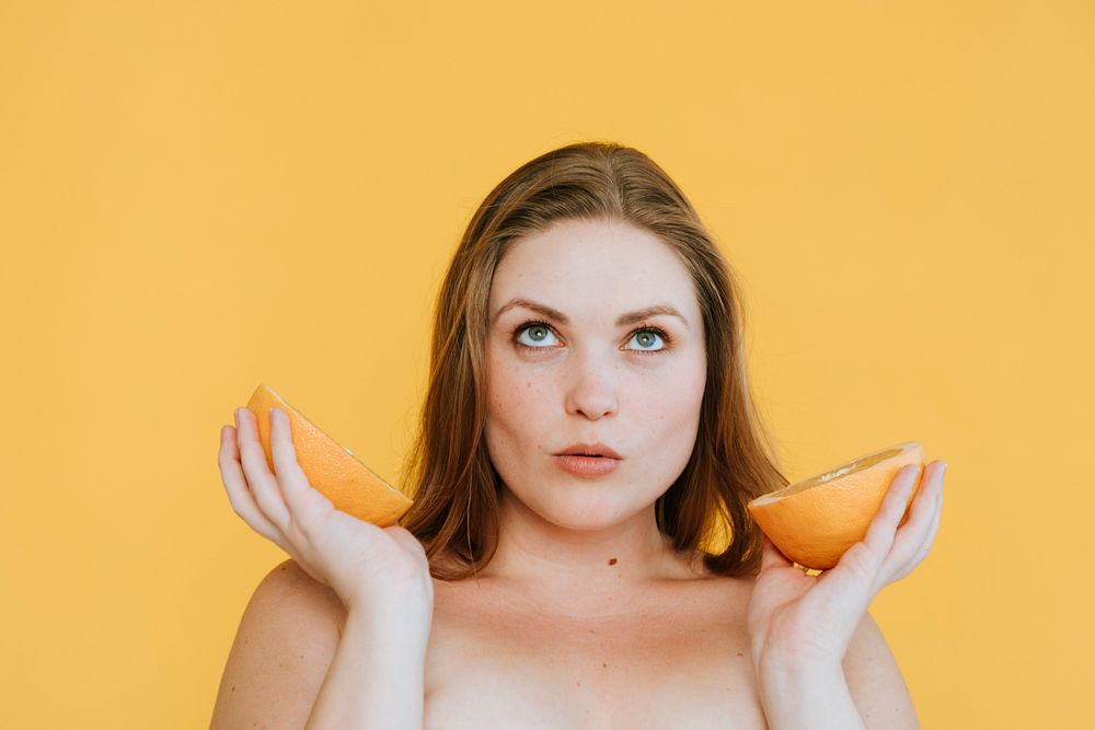 Woman holding two fresh oranges
