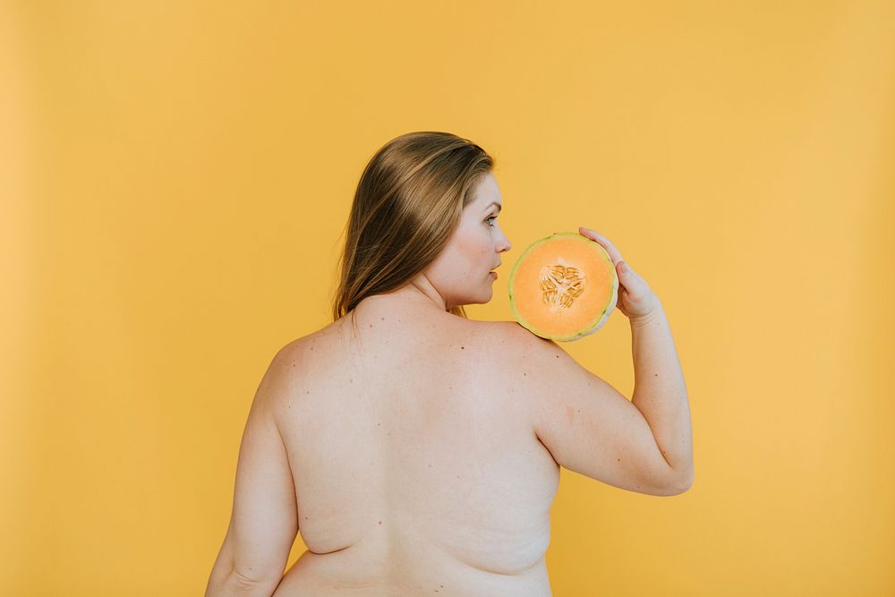 Strong blond woman holding a cantaloupe melon