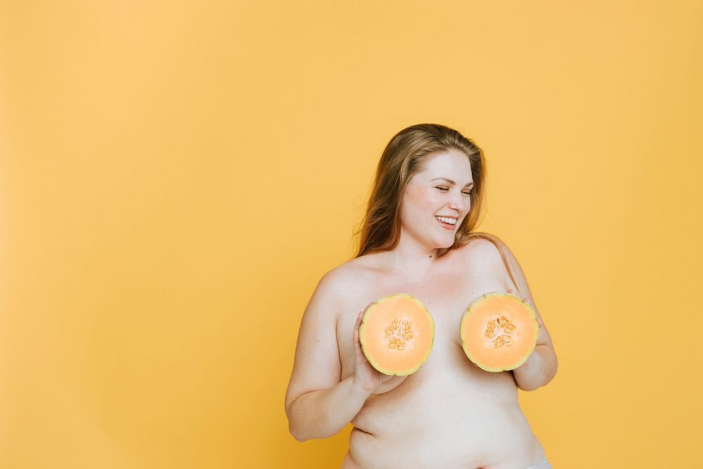 Blond woman holding cantaloupes over her breasts