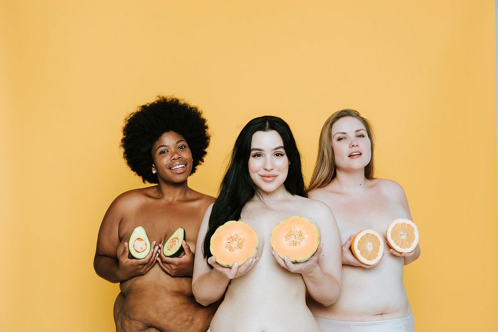 Diverse nude women holding fruits over their breasts