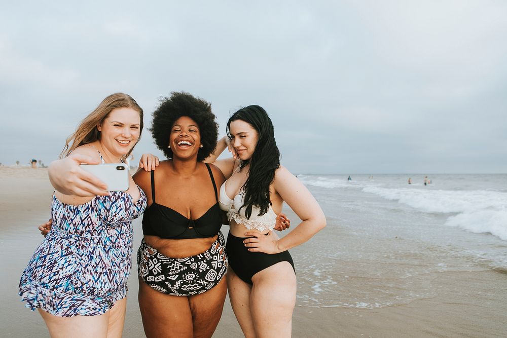 Beautiful confident women taking a selfie at the beach