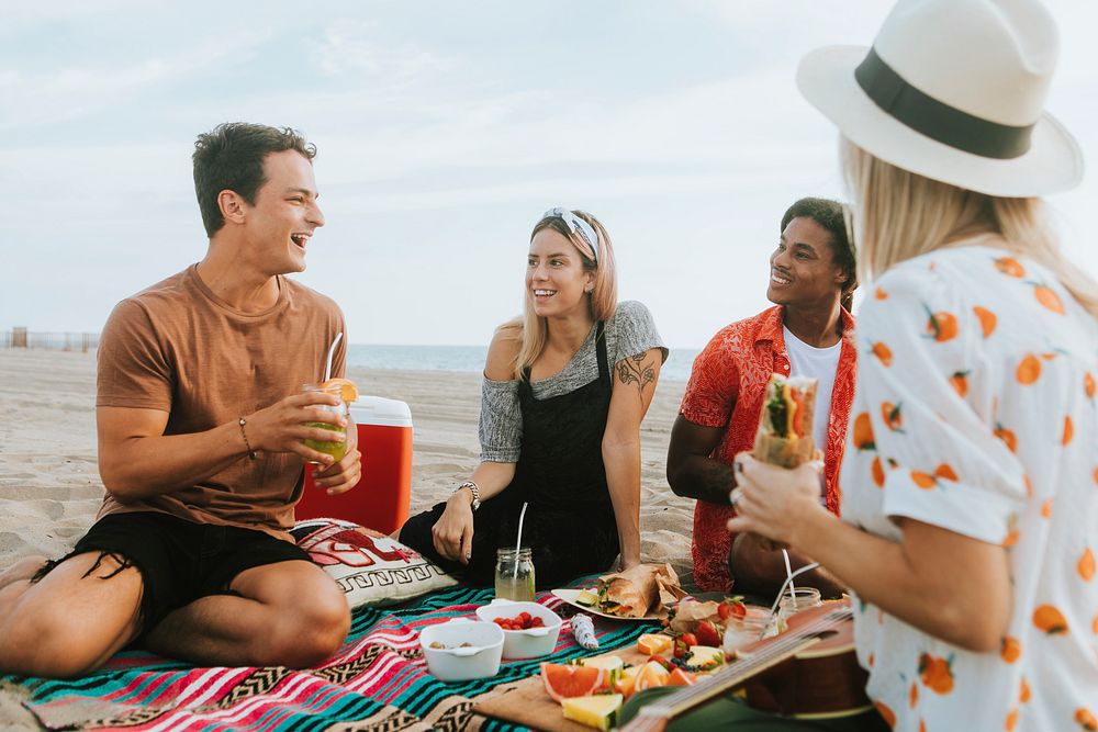 Friends eating food at a beach picnic