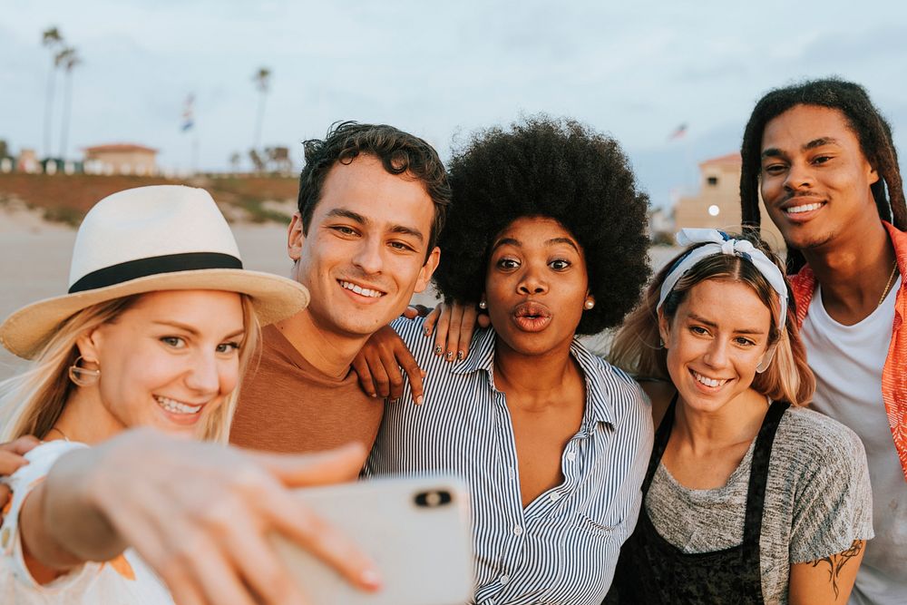 Group of diverse friends taking a selfie at the beach