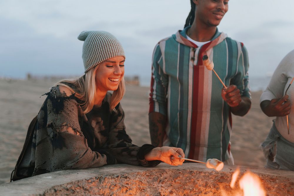 Friends roasting marshmallows at the beach