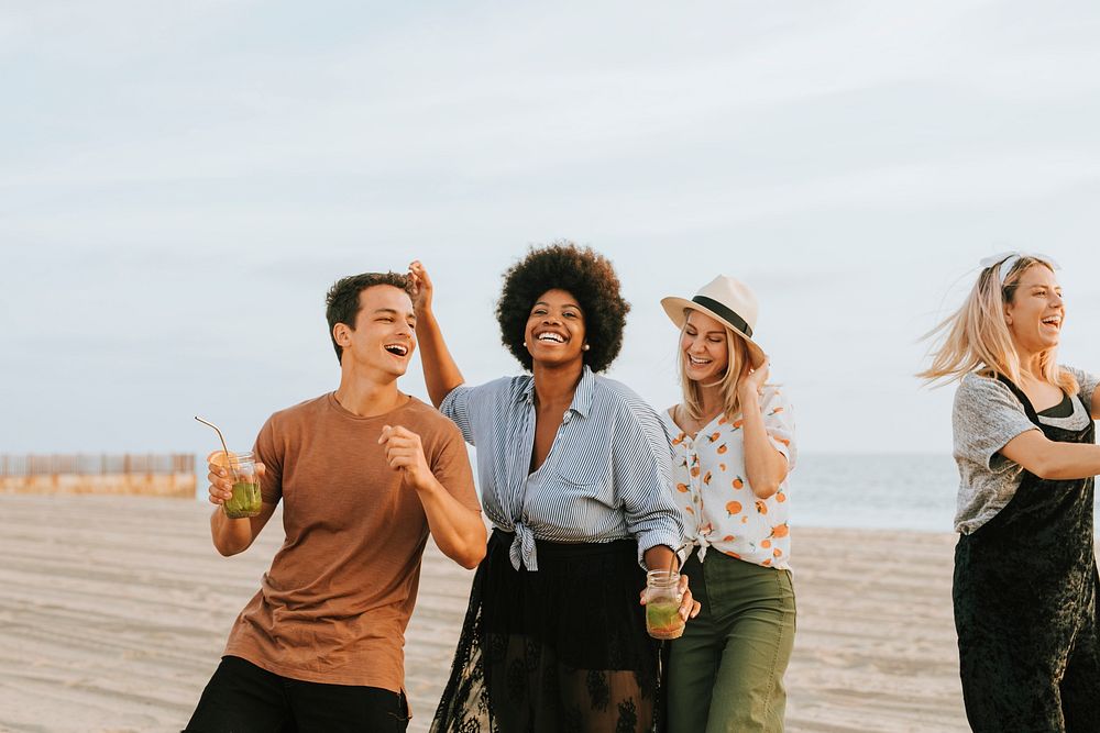 Friends dancing and having fun at the beach