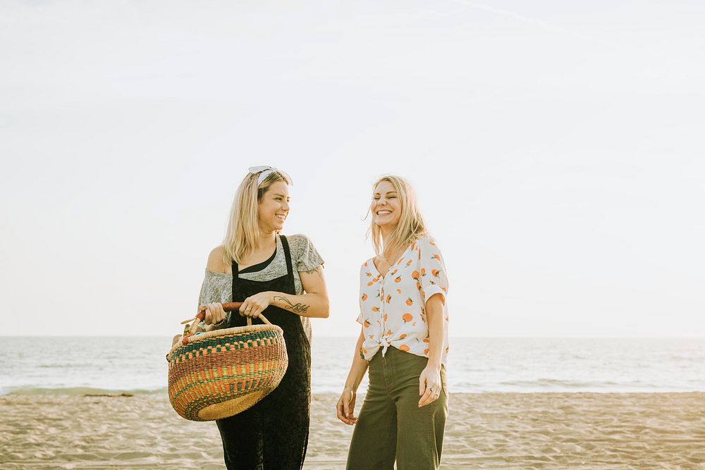 Friends walking at the beach with a picnic basket