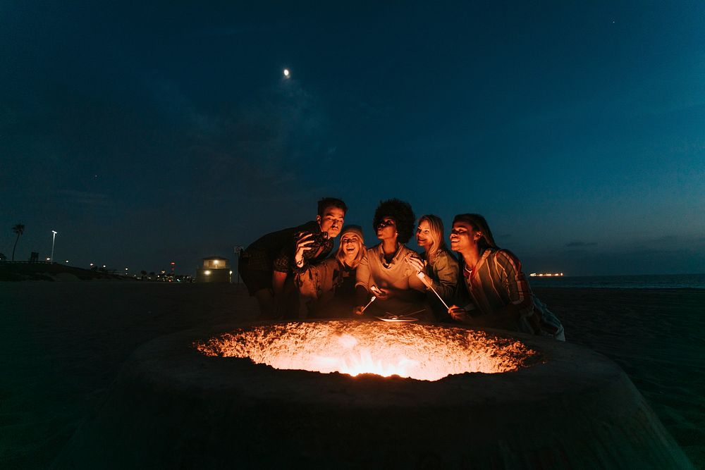 Friends roasting marshmallows over a bonfire