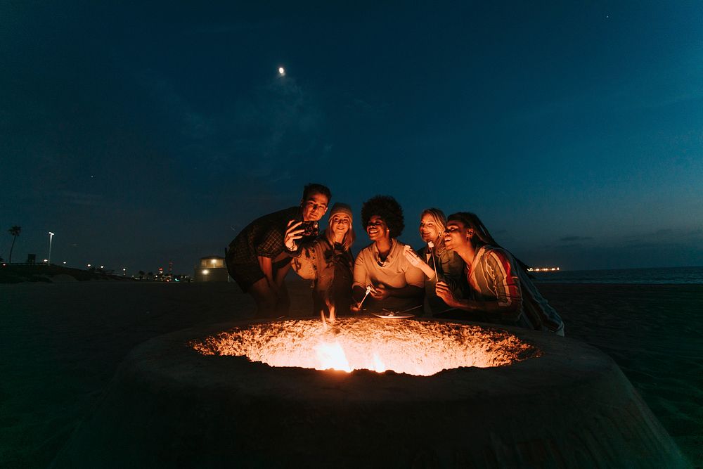 Friends roasting marshmallows over a bonfire