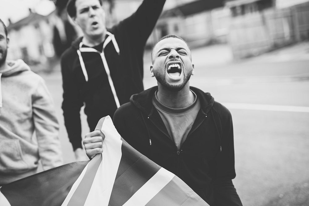 Patriot man holding a UK flag and screaming during a protest