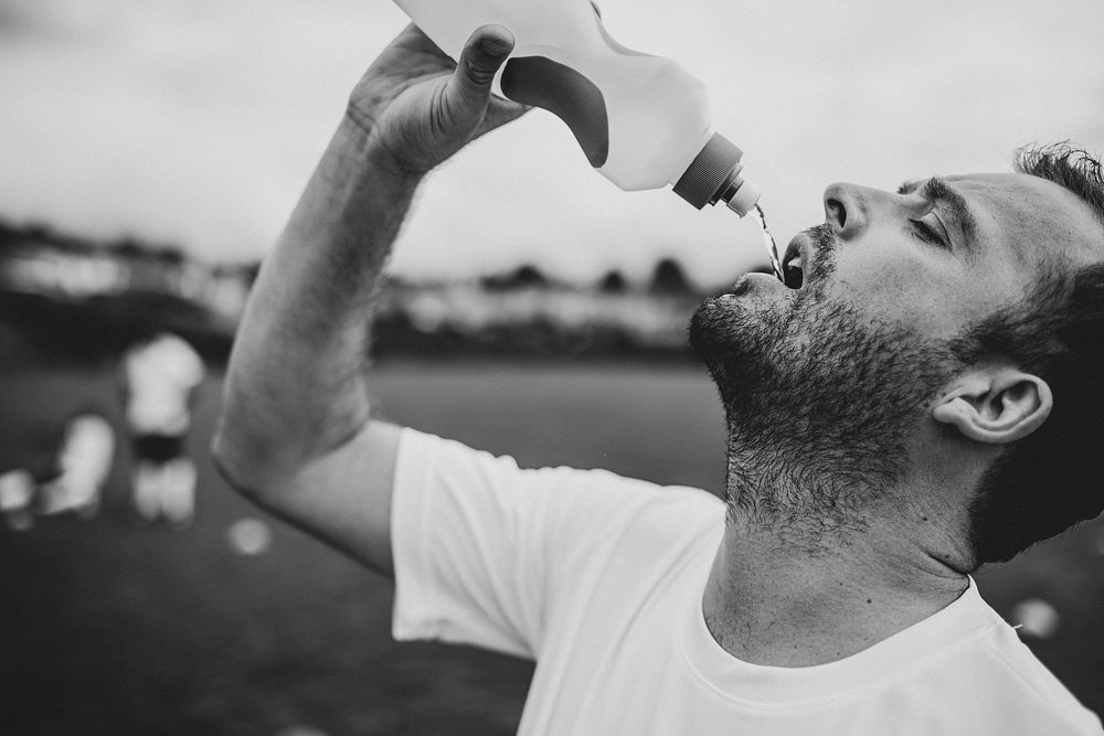 Soccer coach drinking water after soccer game