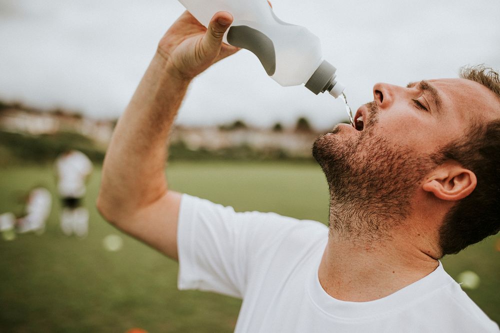 Soccer coach drinking water after soccer game