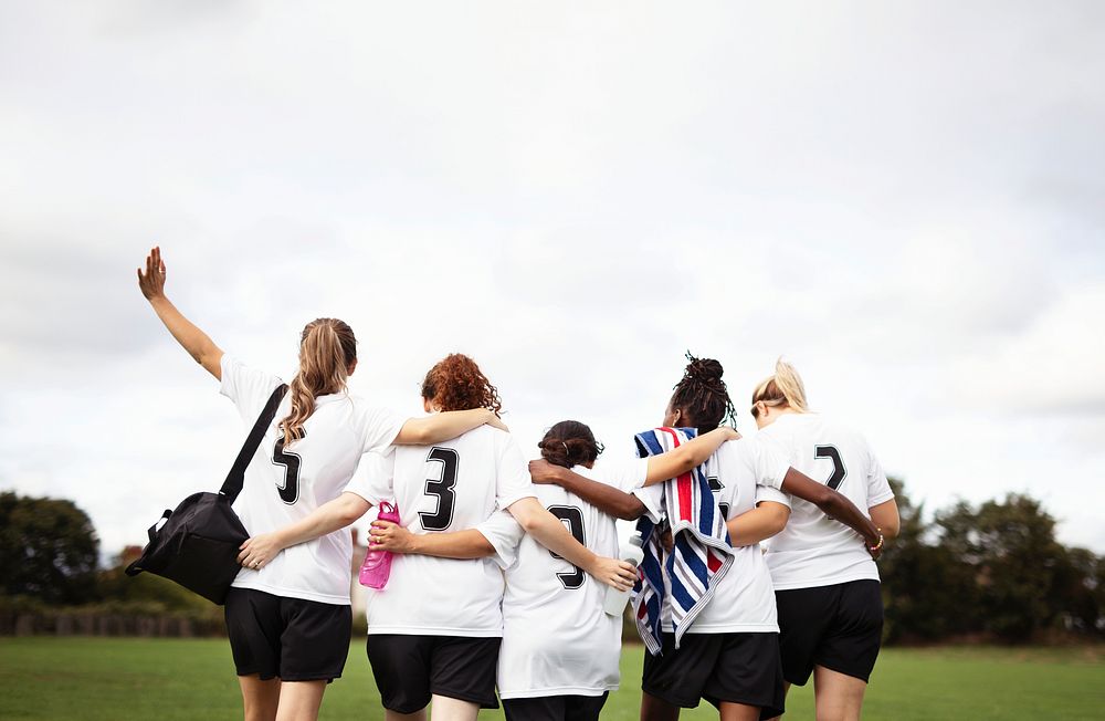 Female football players huddling and walking together