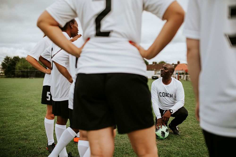 Female football players listening to the coach