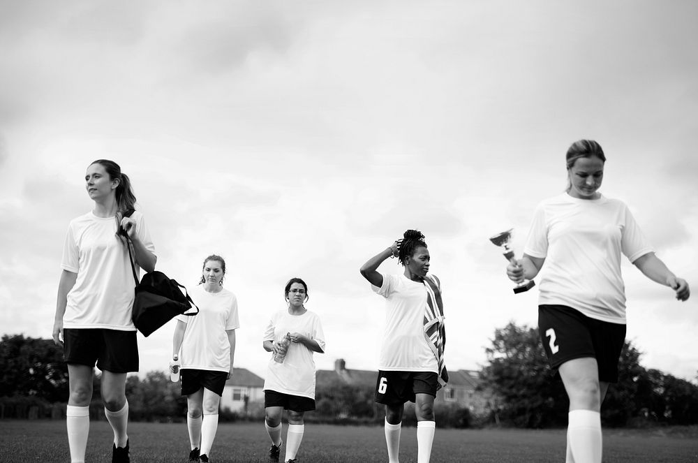 Junior female football players walking on a field