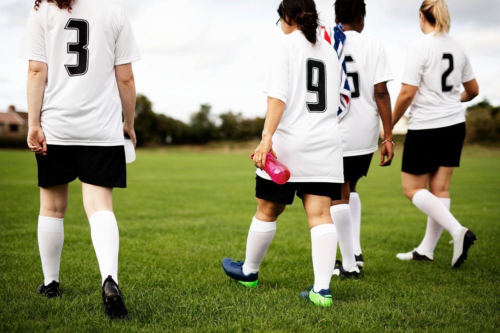 Junior female football players walking on a field