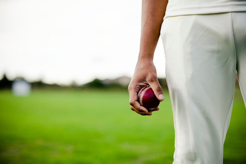 Cricket player holding a leather ball