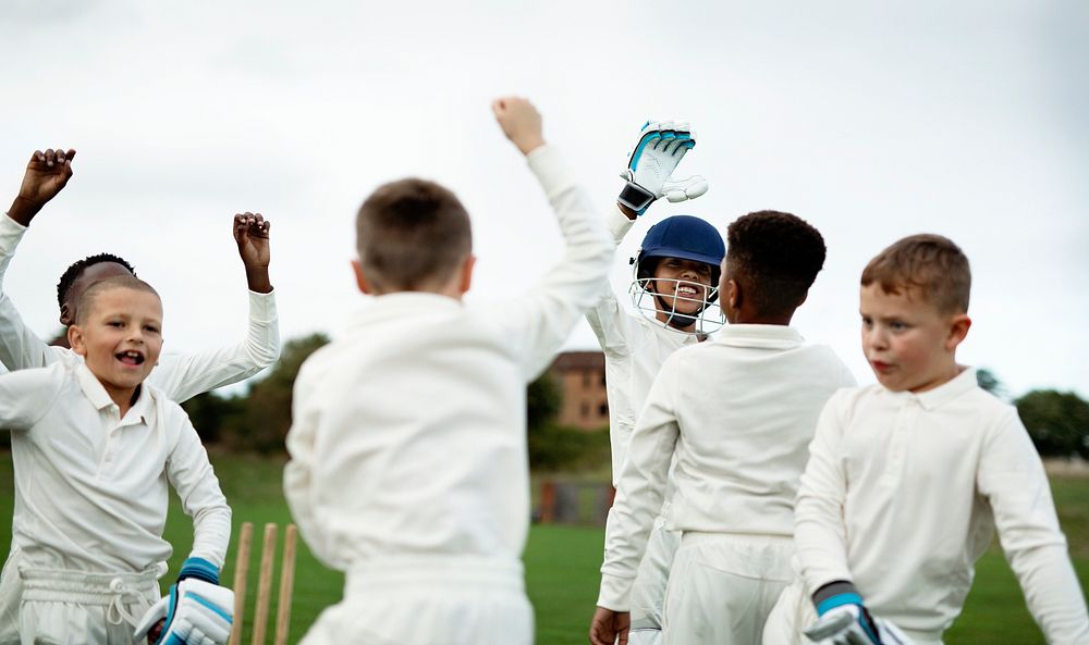 Young happy cricketers cheering on the field