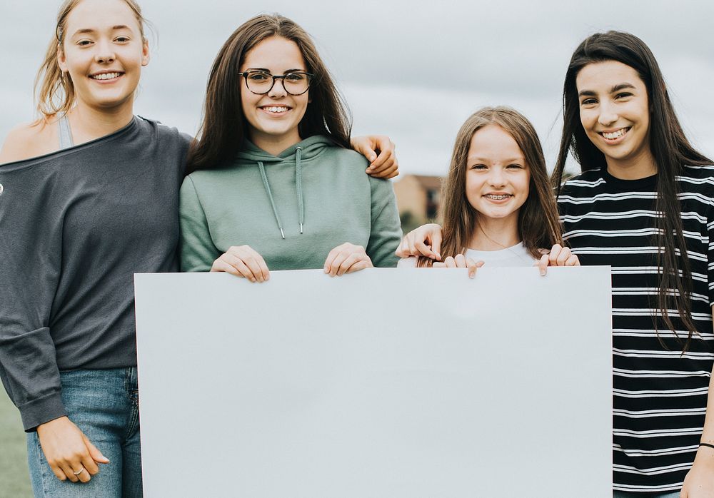 Group of young women showing a blank board