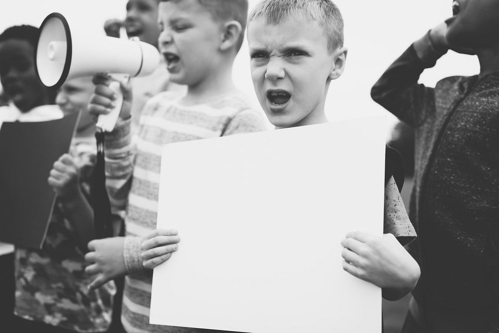 Young boy showing a blank paper in a protest