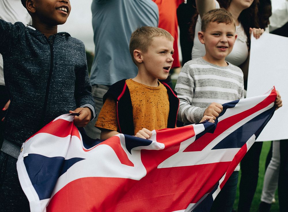 Group of diverse kids showing a UK flag in a protest