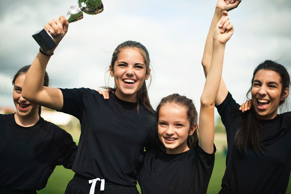 Young female football players celebrating their victory