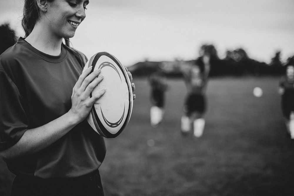 Happy female rugby player holding a ball