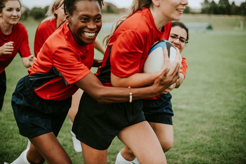 Energetic female rugby players on the field