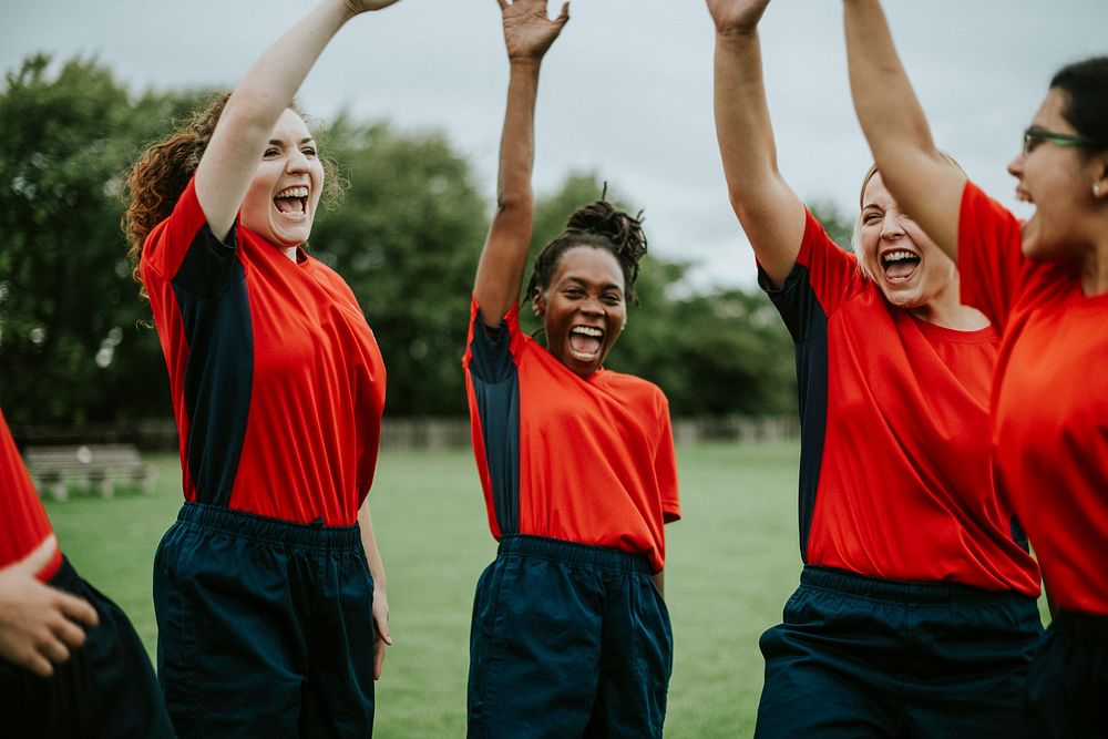 Energetic female rugby players celebrating together