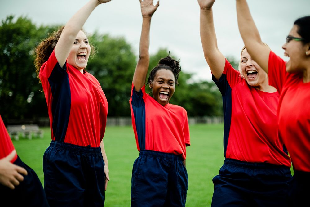 Energetic female rugby players celebrating together