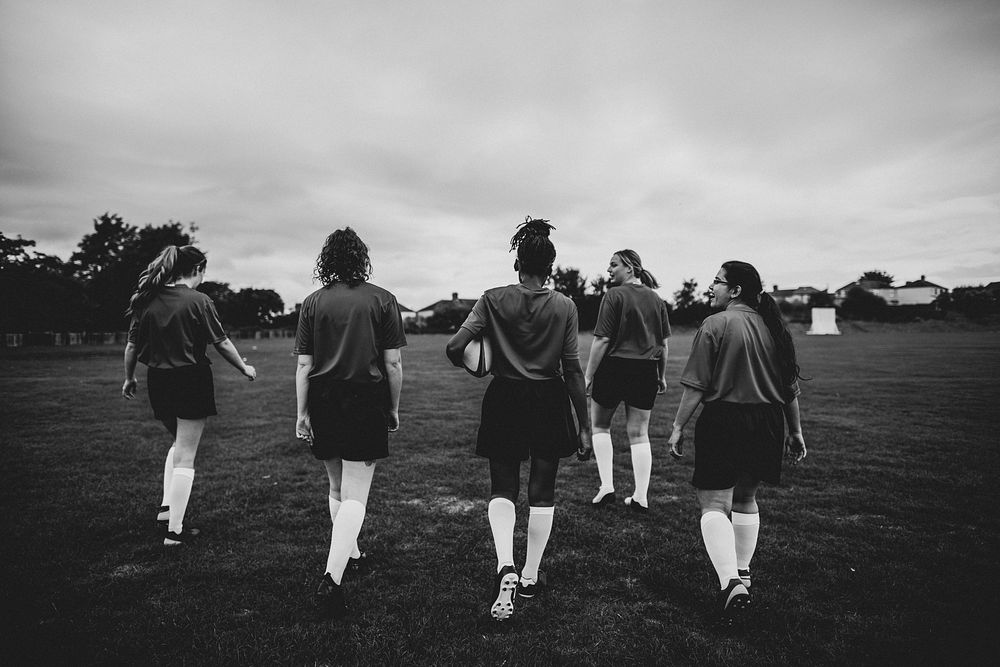 Female rugby players walking on the field