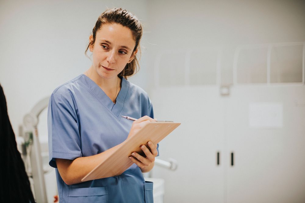 Young female nurse taking notes