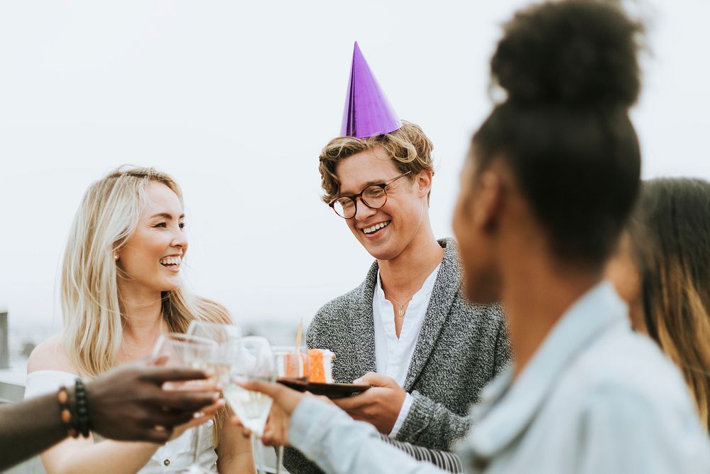 Cheerful friends celebrating at a rooftop birthday party