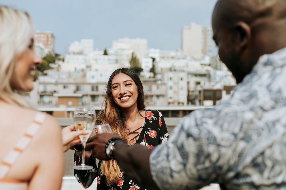 Cheerful friends toasting at a rooftop party