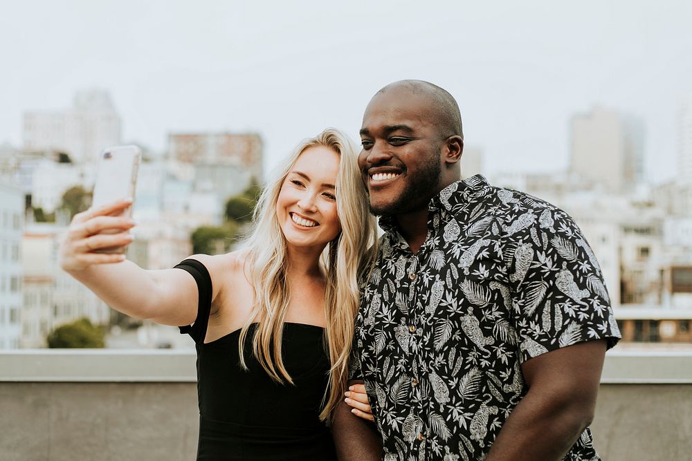 Diverse friends taking a selfie at a rooftop party
