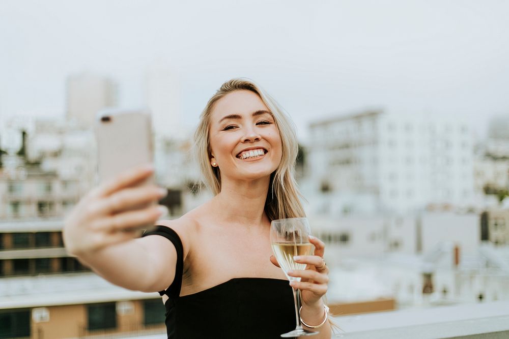 Cheerful woman taking a selfie at a rooftop party