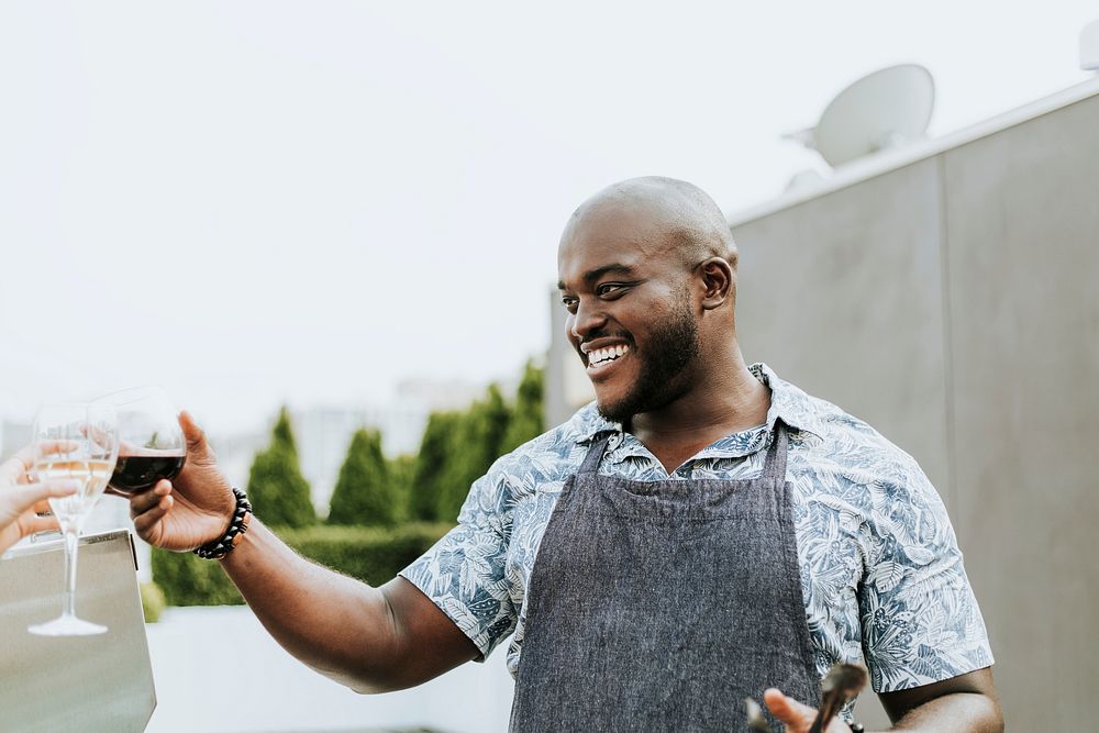 Cheerful chef toasting at a rooftop party