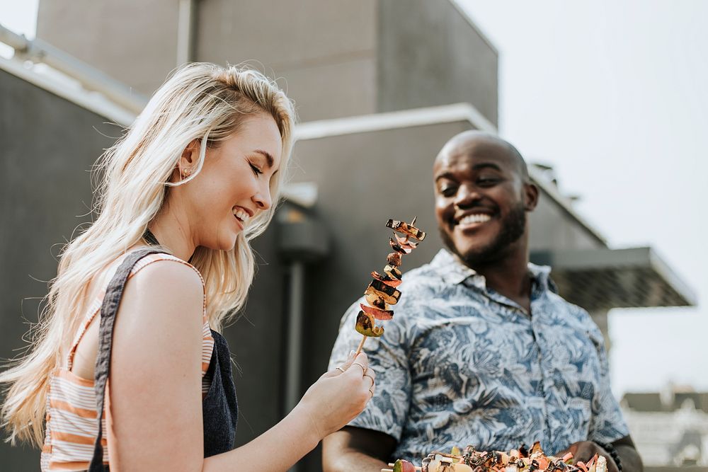 Happy couple preparing barbeque skewers