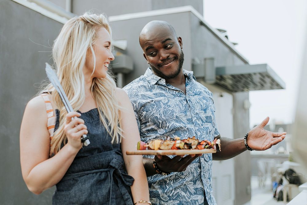 Happy couple preparing barbeque skewers