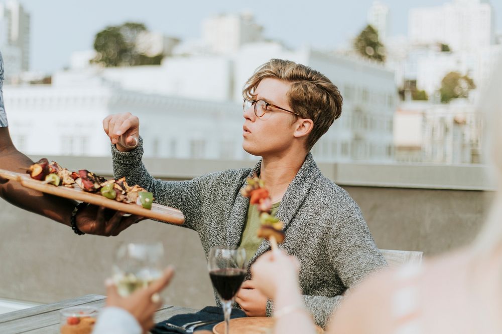 Happy man being served with barbeque skewers