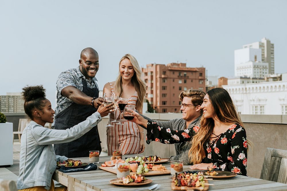 Cheerful friends toasting at a rooftop party