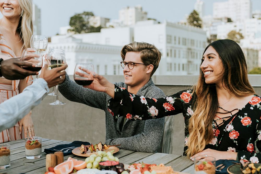 Happy friends toasting at a rooftop party