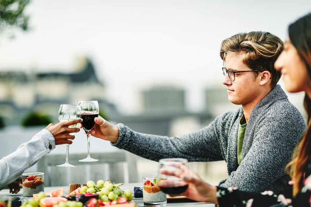 Friends toasting at a rooftop vegan dinner party