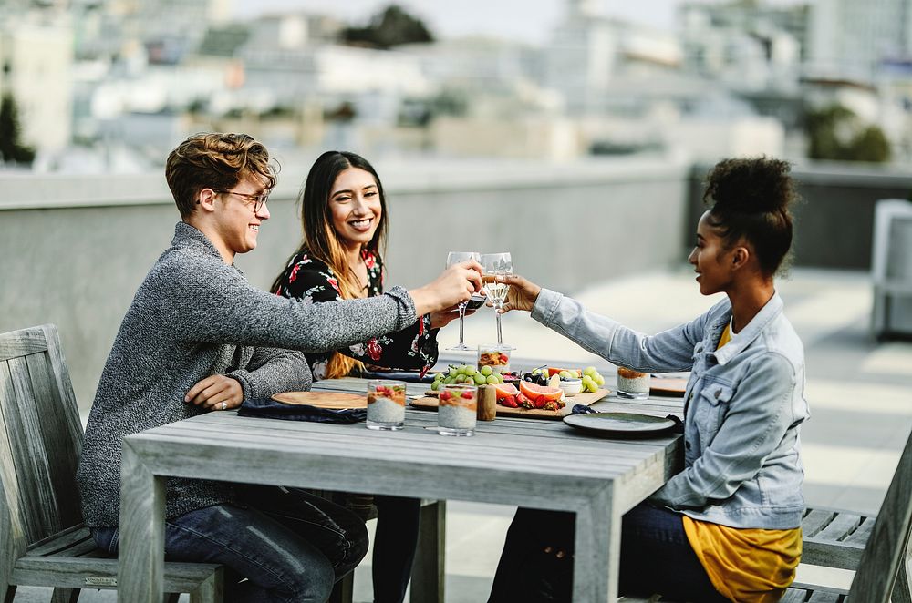 Friends toasting at a rooftop dinner party