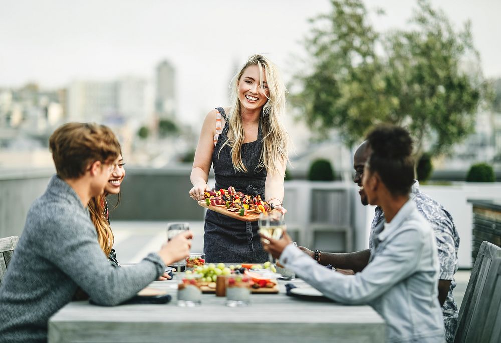 Woman serving vegan barbecue to her friends