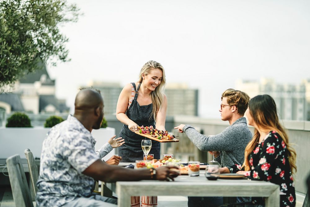 Woman serving vegan barbecue to her friends