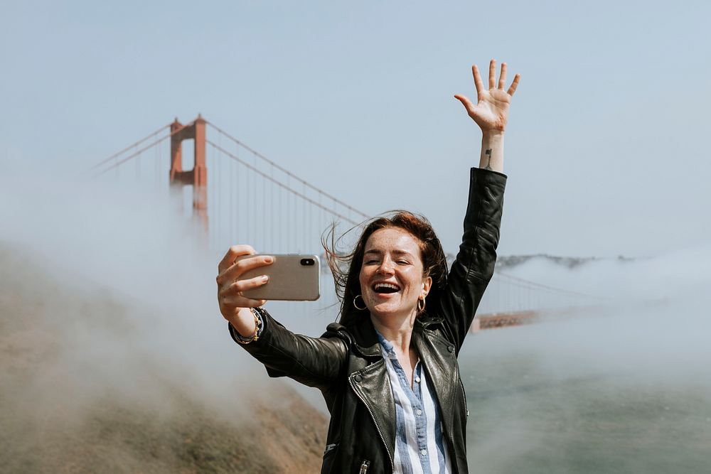 Happy woman taking a selfie with the Golden Gate Bridge, San Francisco