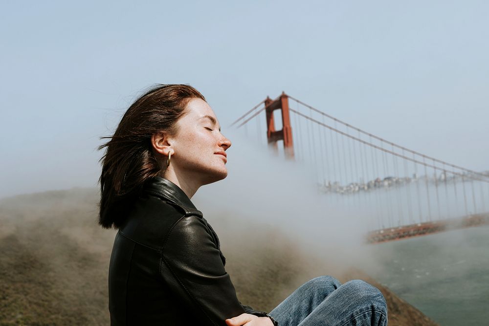 Woman enjoying the cool breeze with a view of the Golden Gate Bridge, San Francisco