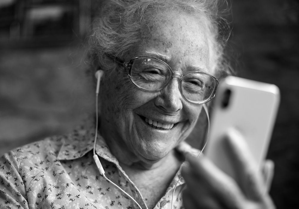 Happy elderly woman playing on the phone