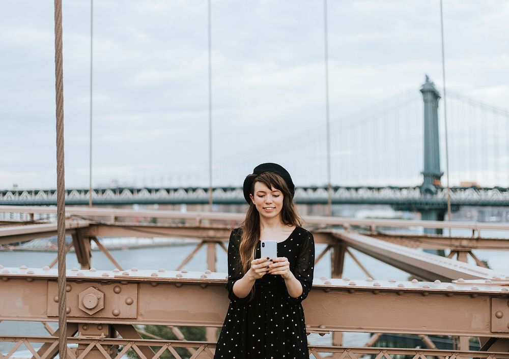 Woman texting at the Brooklyn Bridge, USA